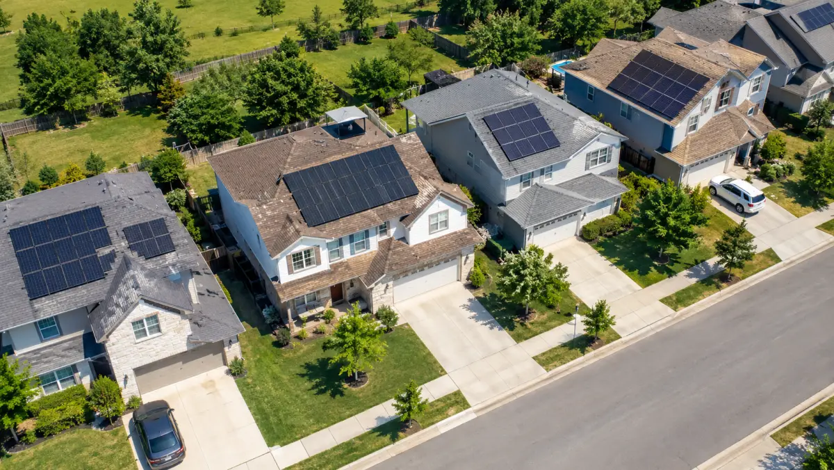 Aerial view of suburban homes with rooftop solar arrays
